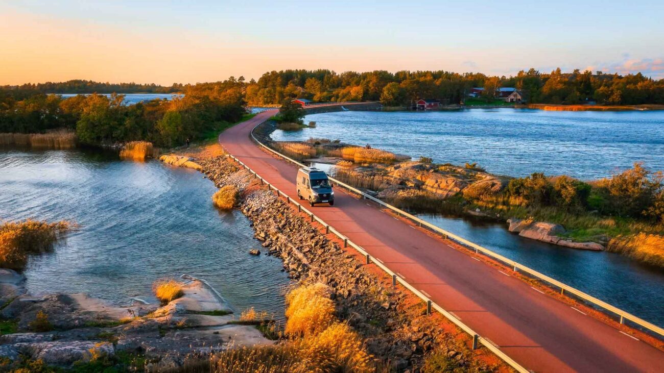 Camperwagen fährt über Brücke zwischen Seen